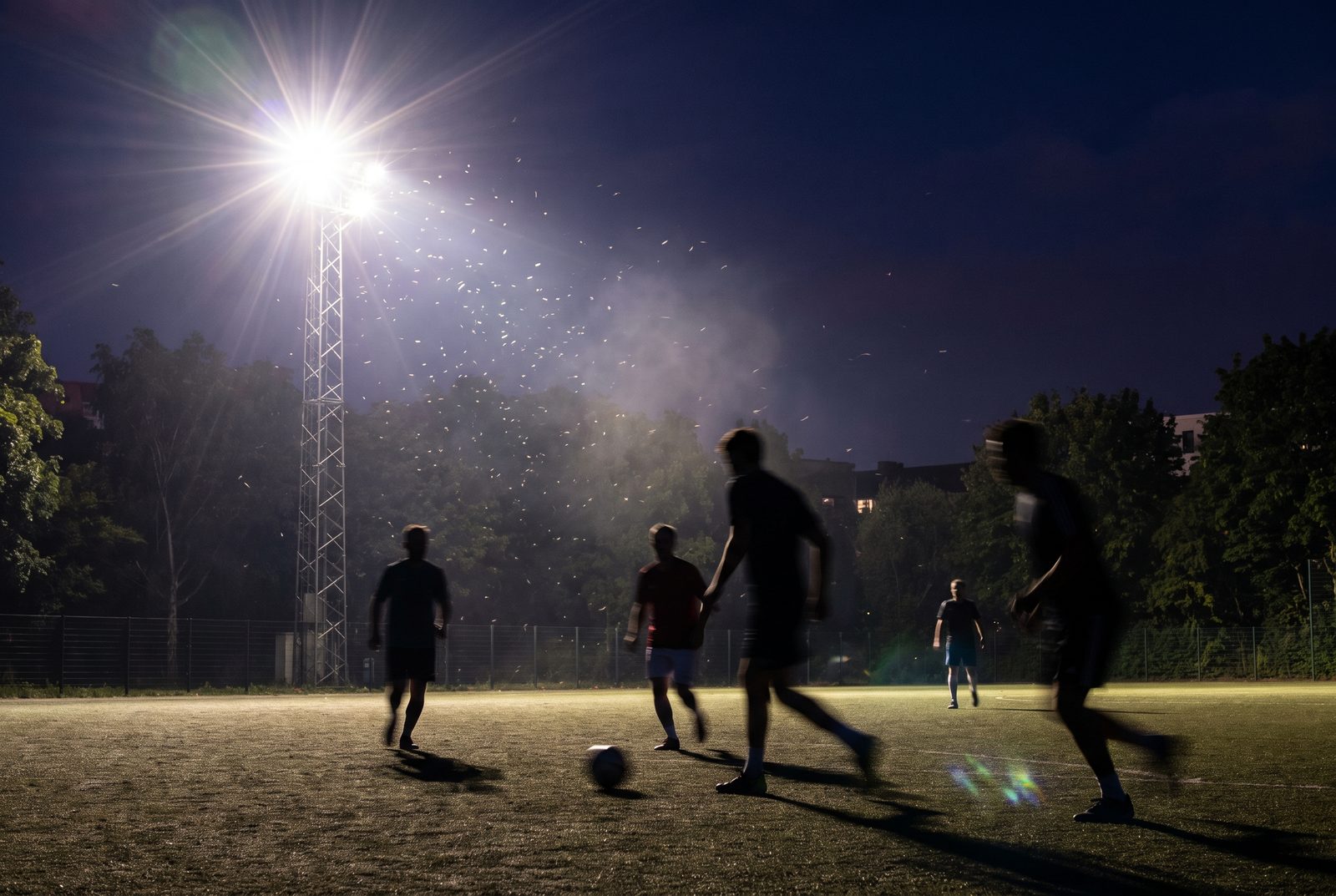 Illustrative image: silhouetted players under floodlights at an evening match